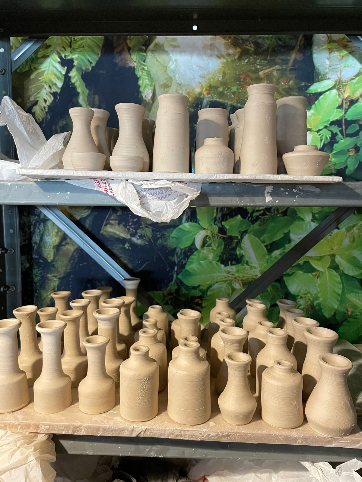 Rows of raw ceramic bottles before firing